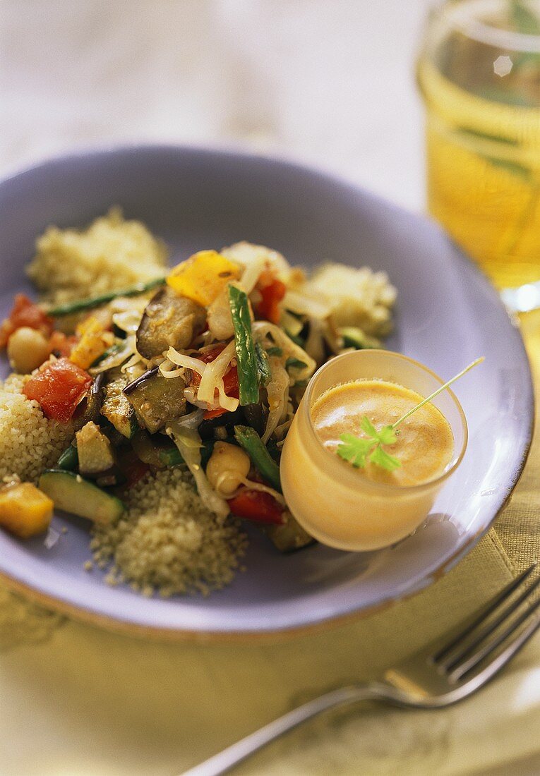 Couscous mit Gemüse und Dip auf einem Teller