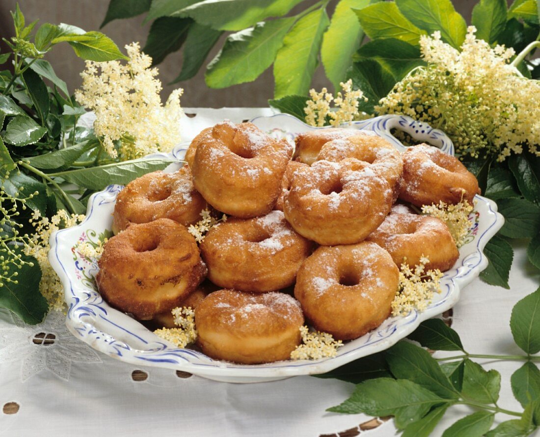 Coiled doughnuts (Schmalzkringel) with elderflowers