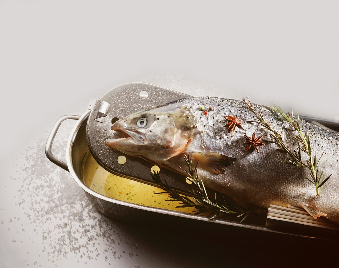 Whole poached salmon in a roasting dish