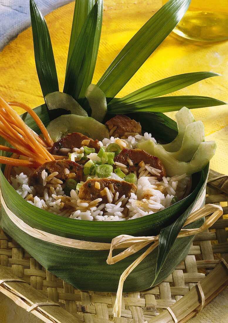 Thai rice dish with pork fillet in banana leaf