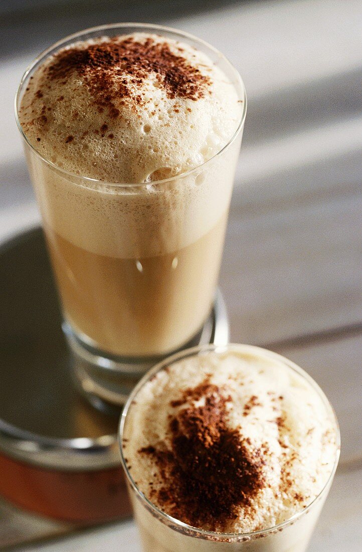 Two glasses of white coffee with milk froth