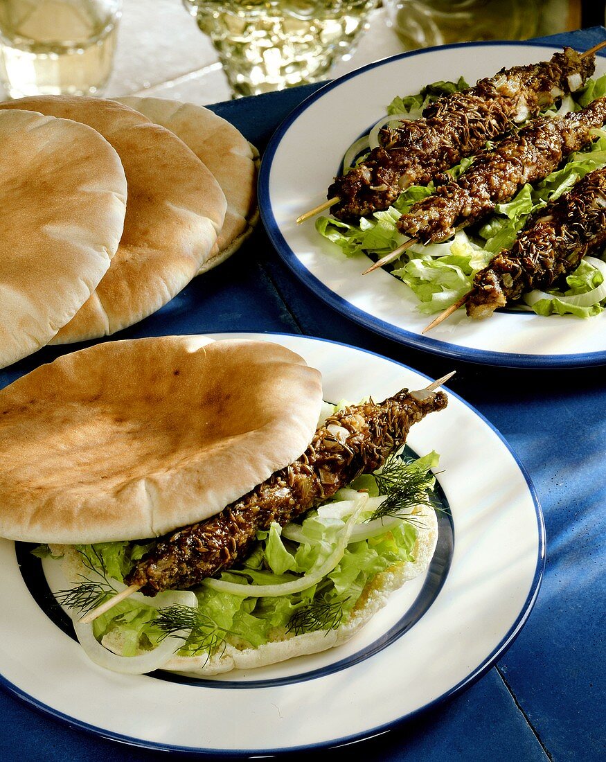 Lamb kebabs on salad and pitta rolls