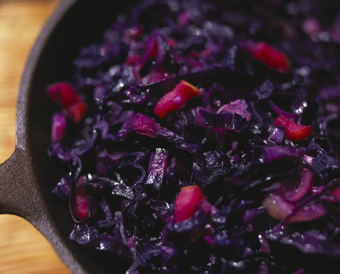 Red cabbage with onions and diced apples in pan