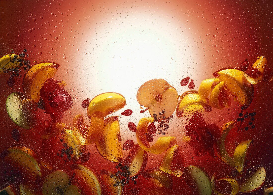 Verschiedene Früchte und Fruchtscheiben im Glasbecken