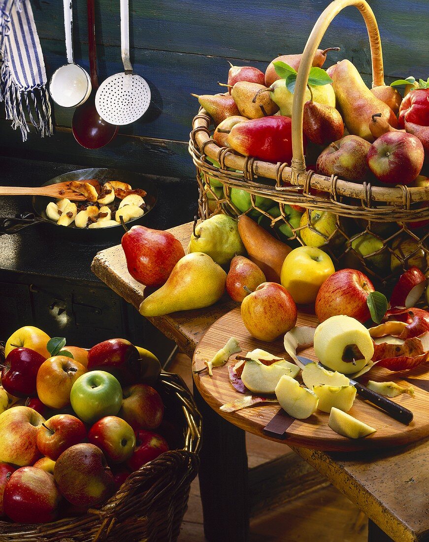 Äpfel und Birnen in Weidenkörben und auf dem Tisch