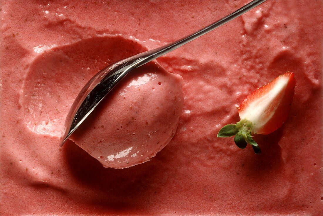 Yoghurt and strawberry ice cream in shallow dish with spoon