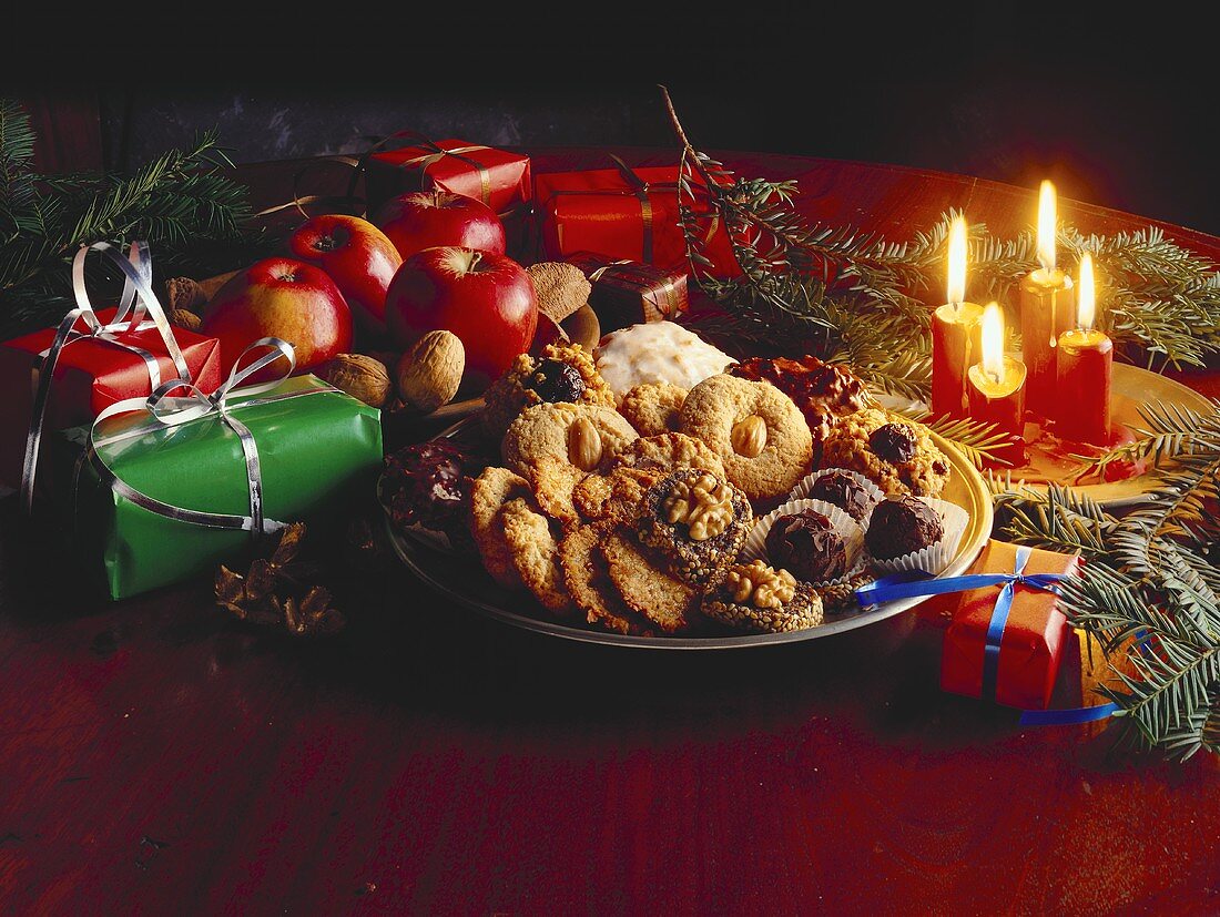 Weihnachtsplätzchen mit Geschenken, Äpfeln und Kerzen