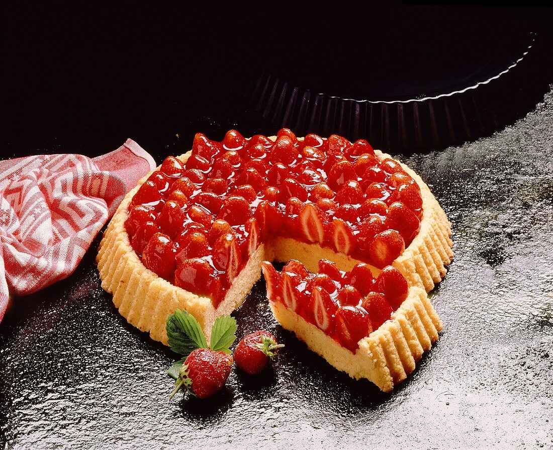 A strawberry flan, a piece cut