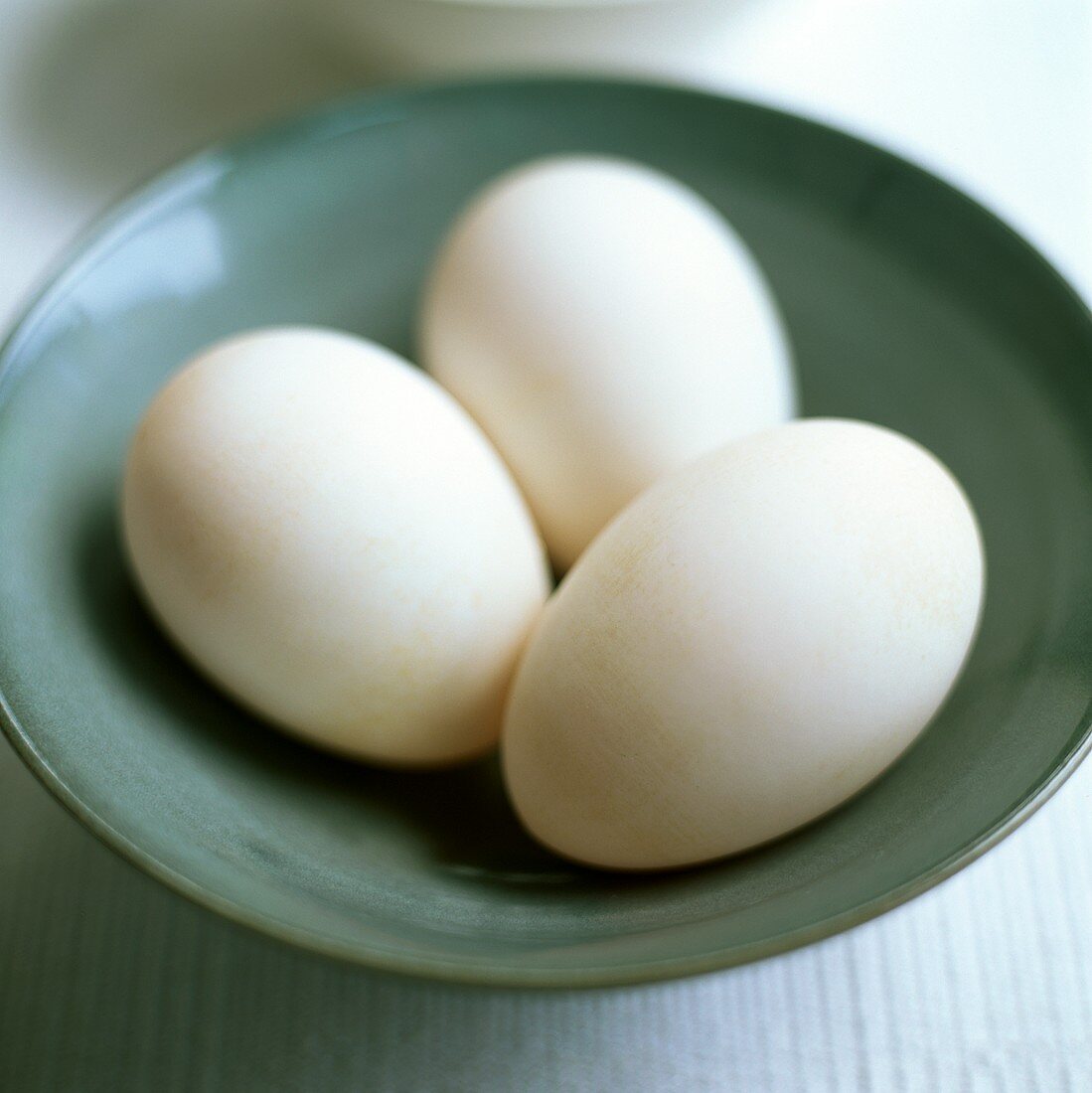 Three white eggs on a plate