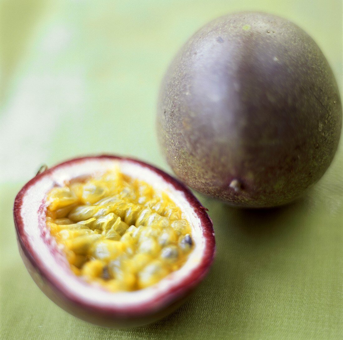 Passionsfrüchte, ganz und halbiert (Purpurgranadilla)