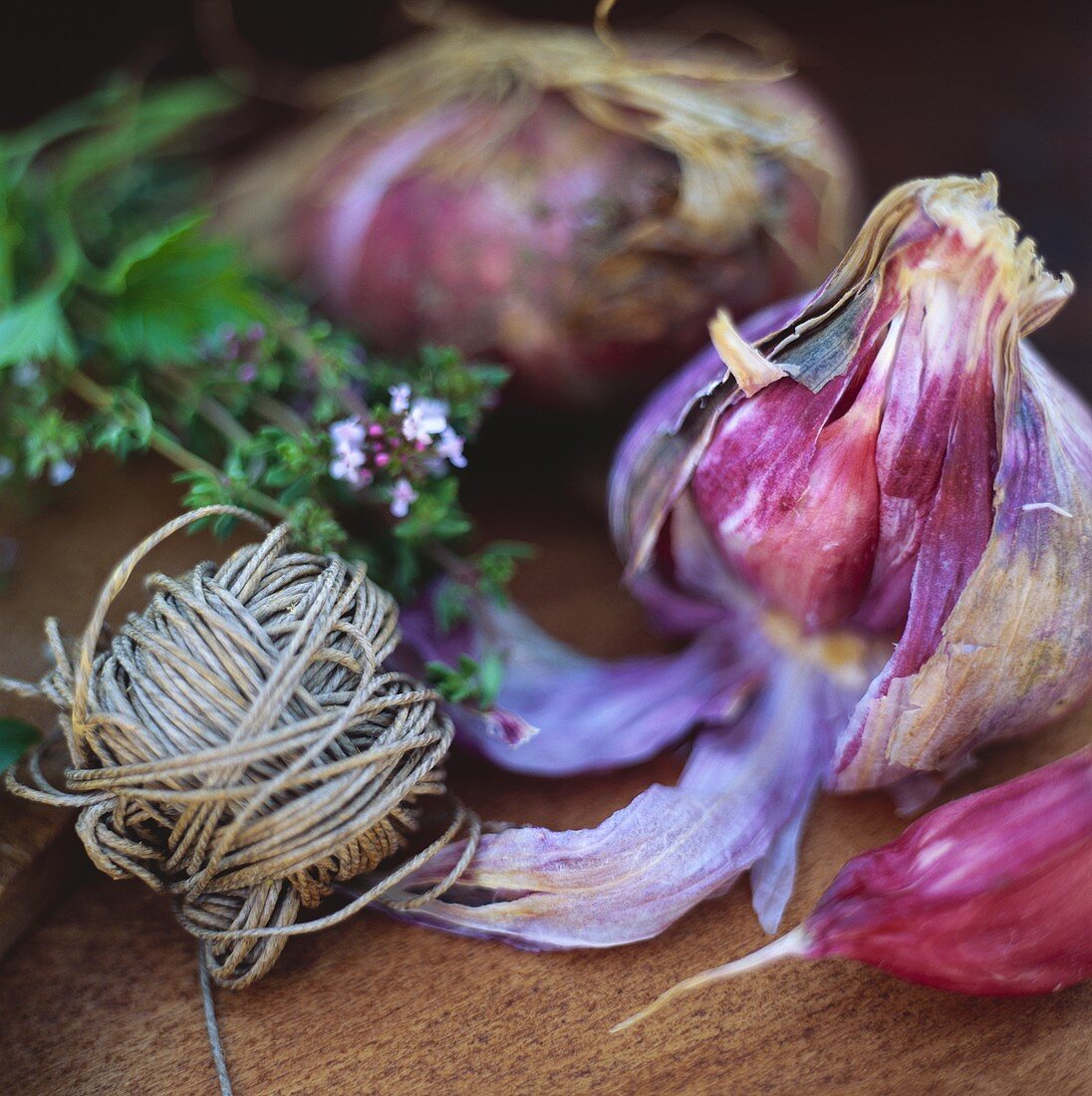 Red garlic and string on wooden board