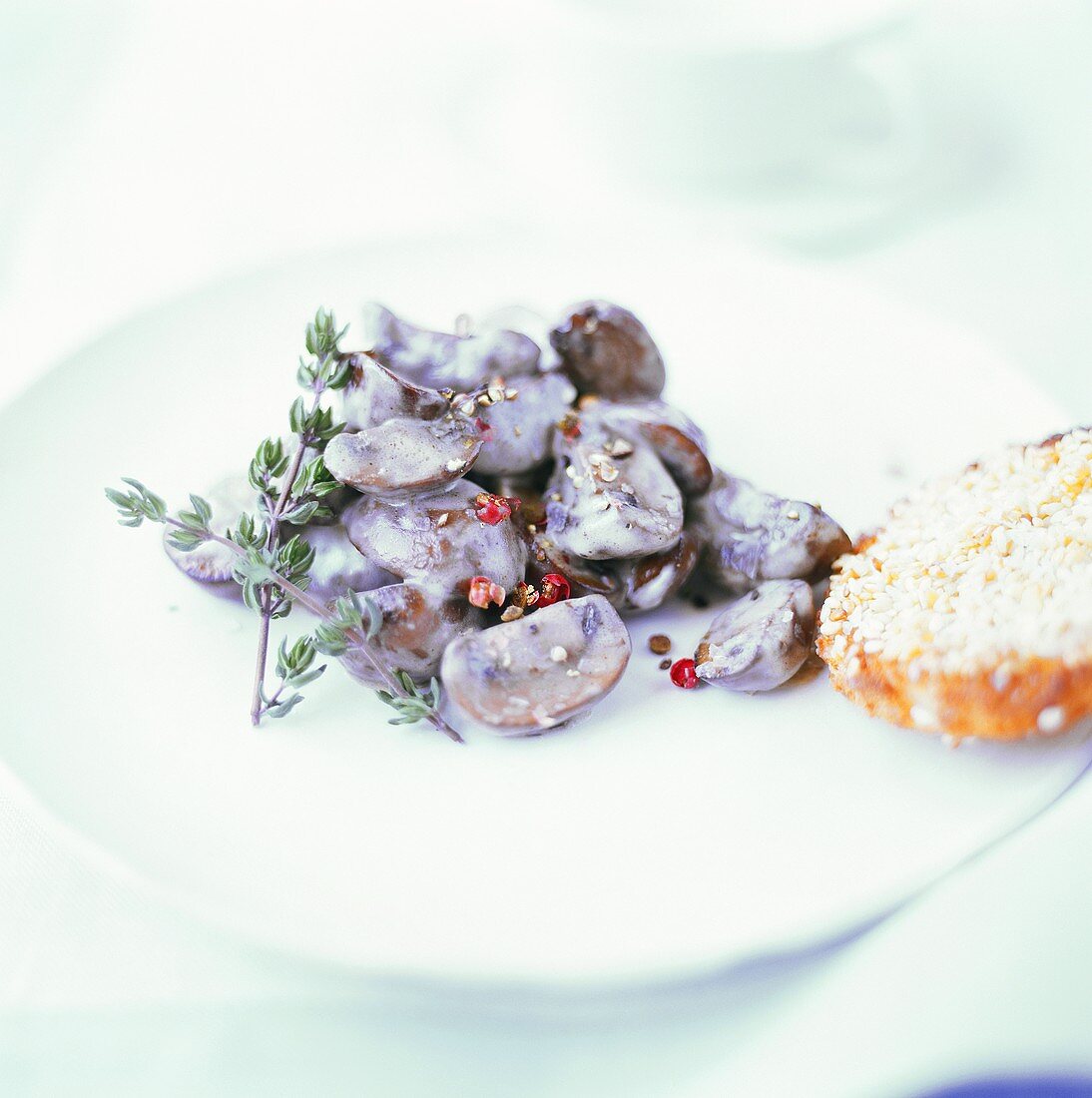 Button mushrooms with red peppercorns in cream sauce
