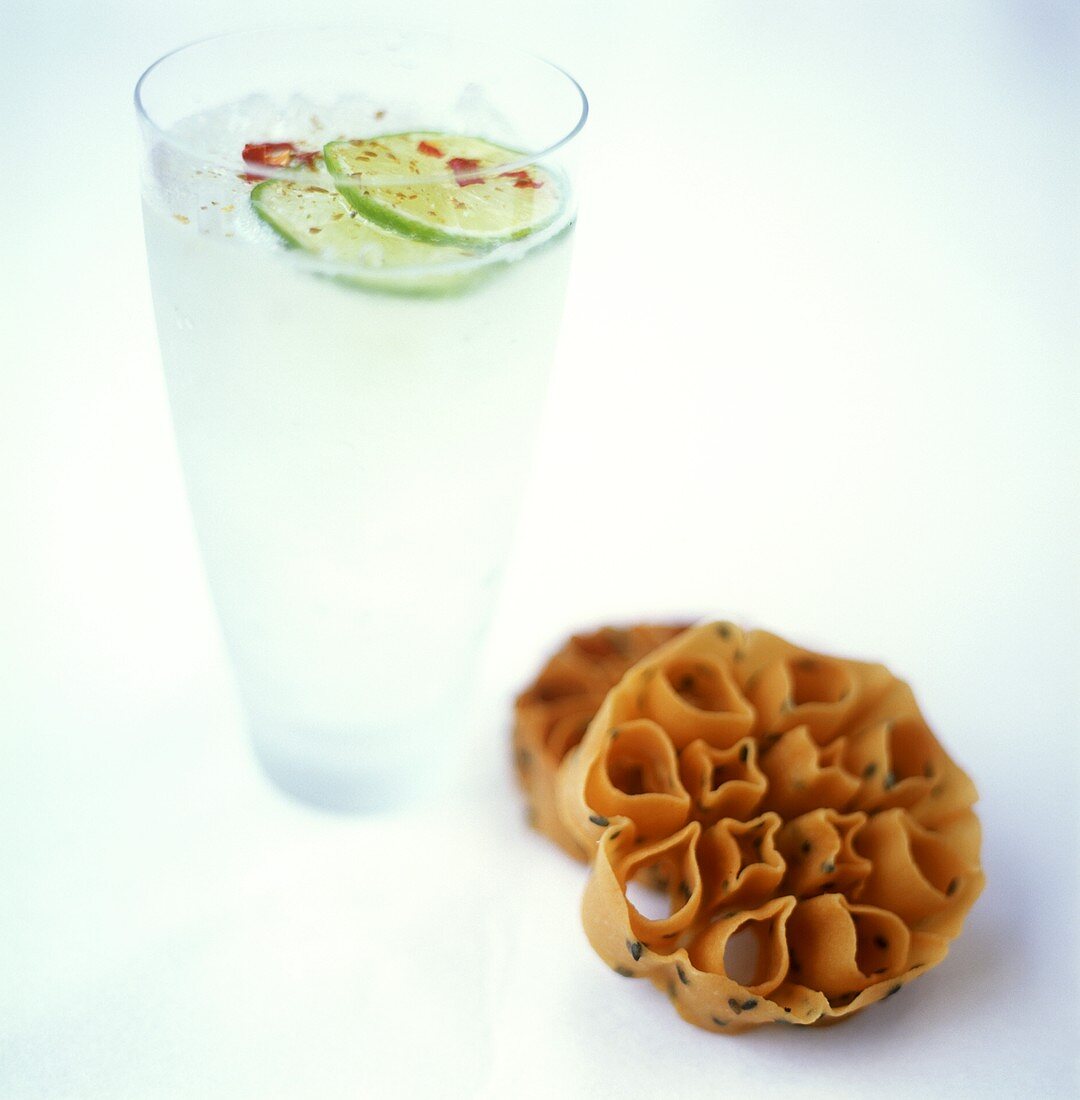 A glass of lemonade with limes & chili, with sesame pastry