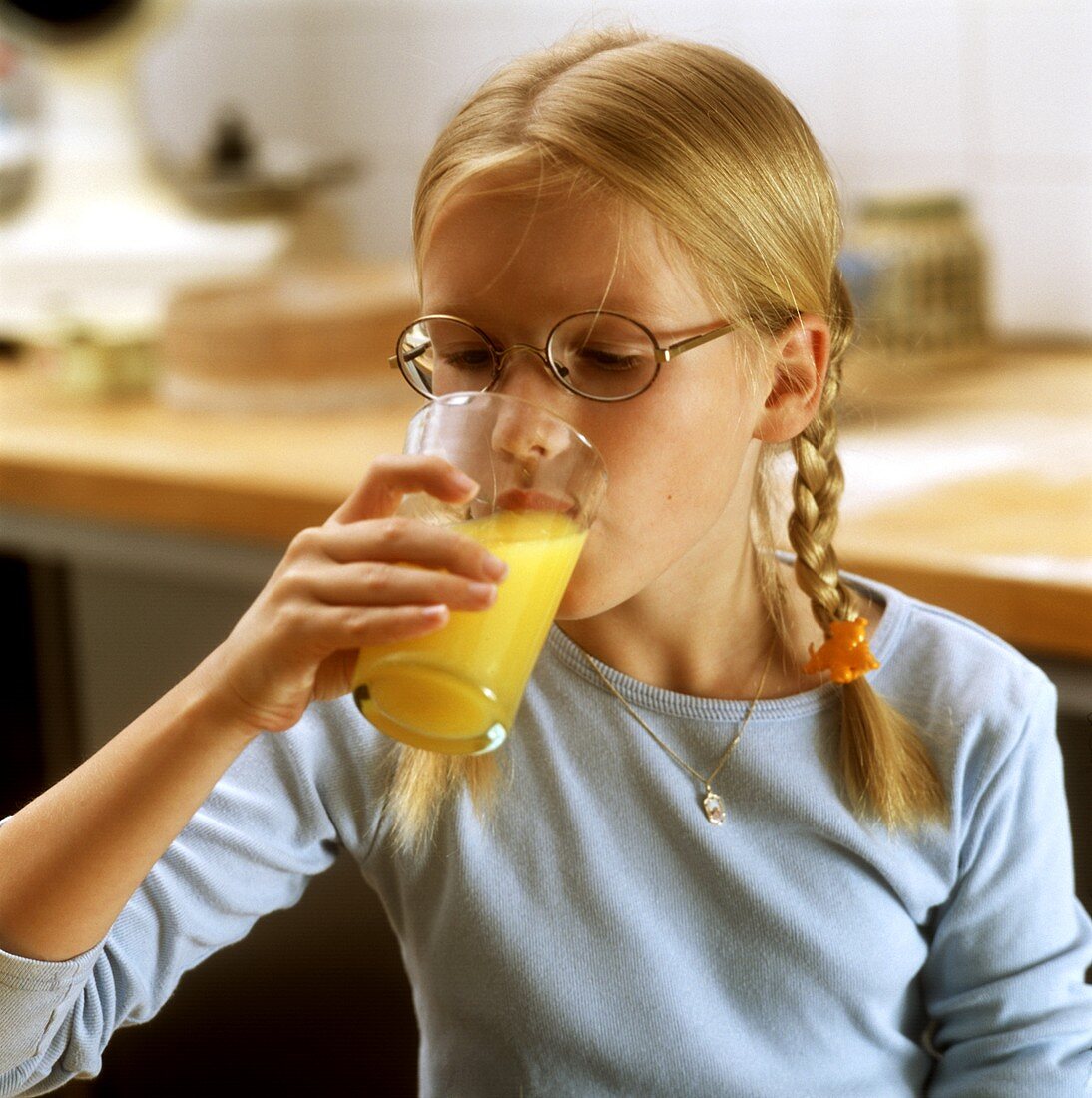 Blond girl drinking orange juice