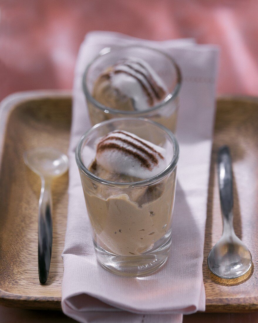 Cappuccinocreme mit Sahnehäubchen und Kakao im Glas