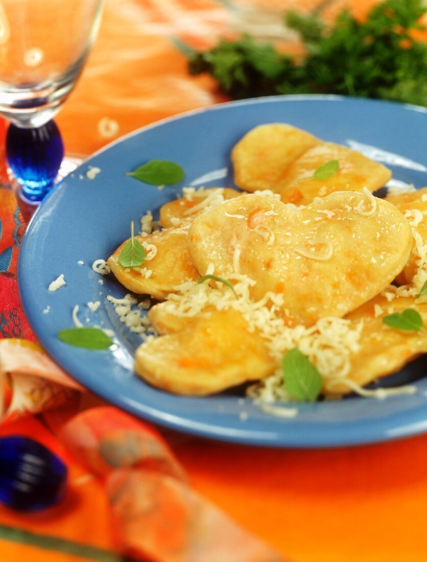 Heart-shaped pumpkin ravioli with cheese and sage leaves