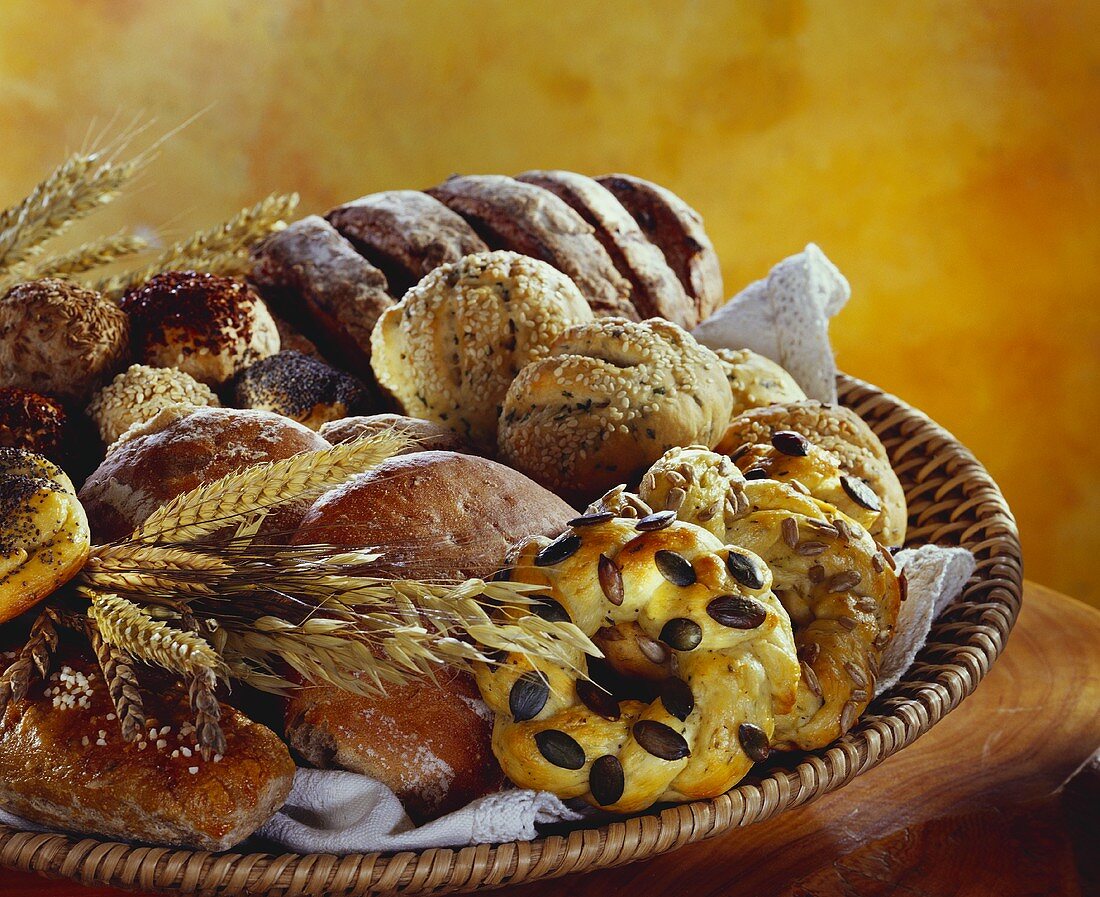 Loaves of bread and rolls with cereal ears in bread basket