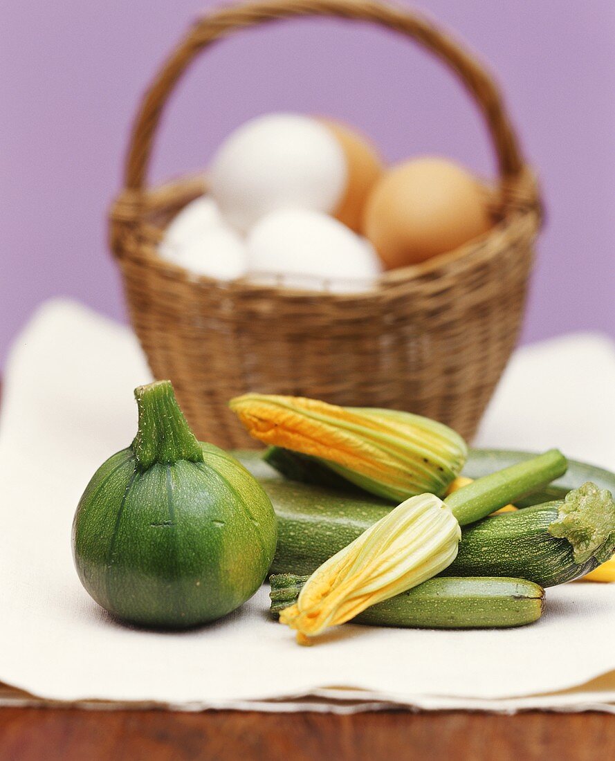 Stillleben mit Zucchini, Rondini und Eierkorb