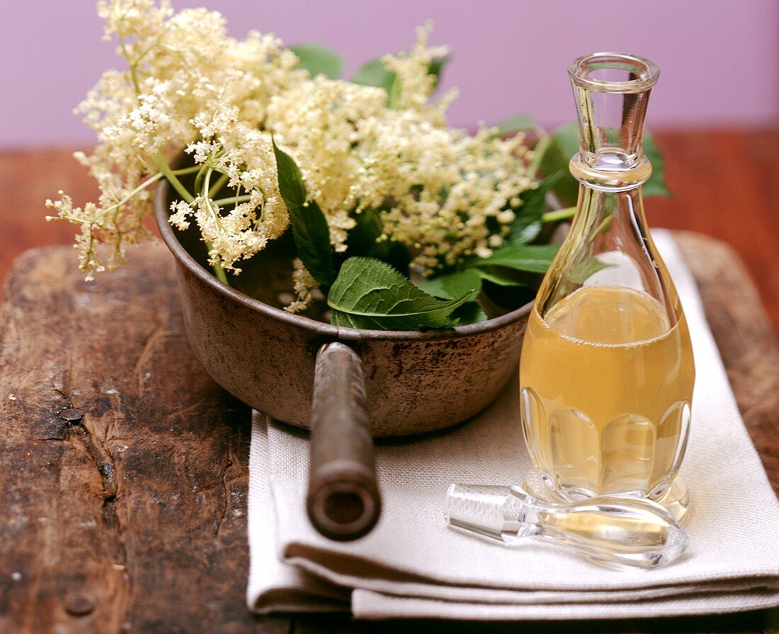 Still life with elderflower syrup and elderflowers