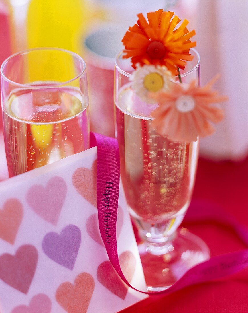 Two champagne glasses with summery birthday decorations