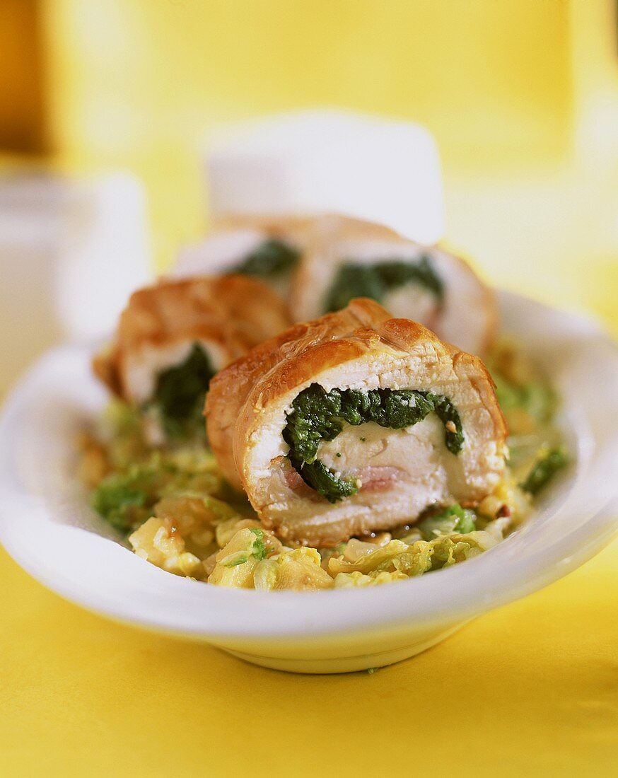 Turkey roulade with spinach filling on vegetables