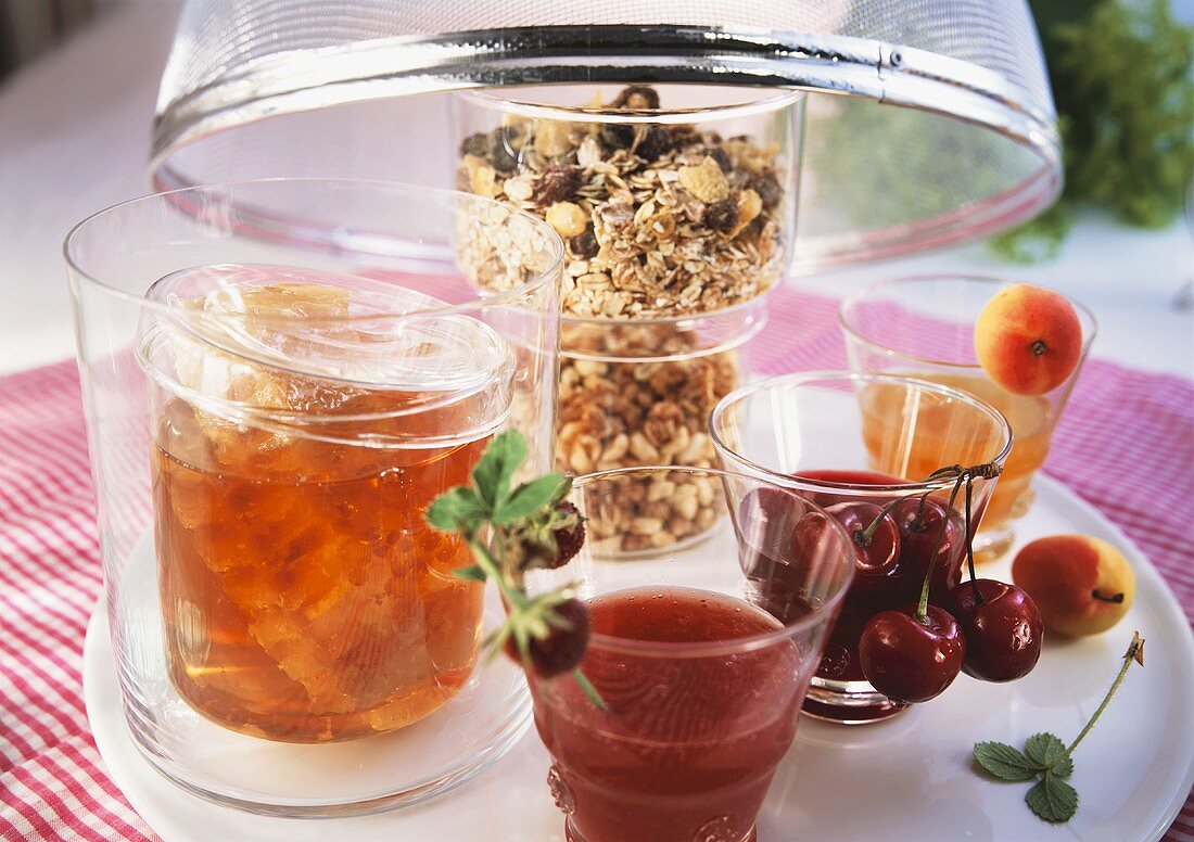 Verschiedene Marmeladen, Honig und Müsli in Gläsern