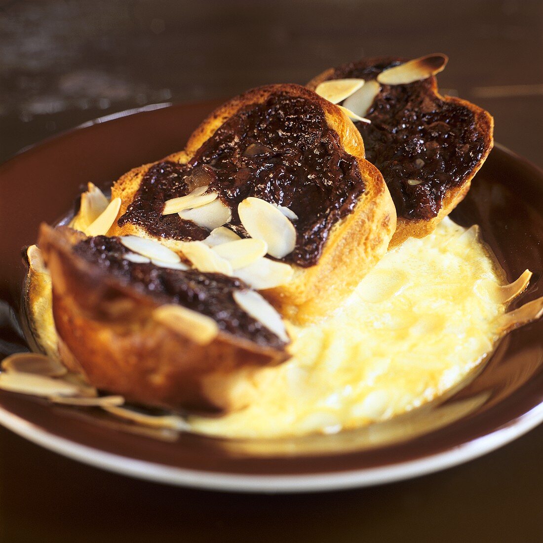 Überbackene Brioches mit Schokoladensauce und Mandeln