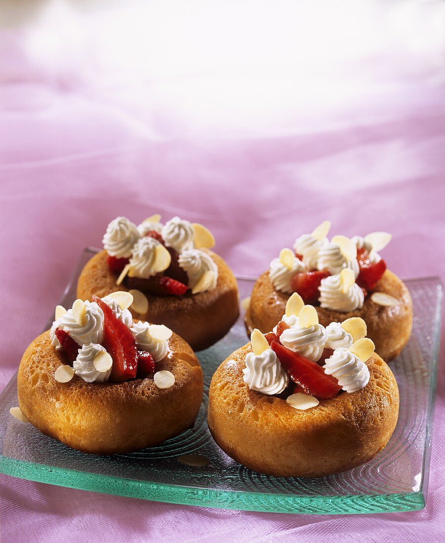 Small strawberry savarins with cream and flaked almonds