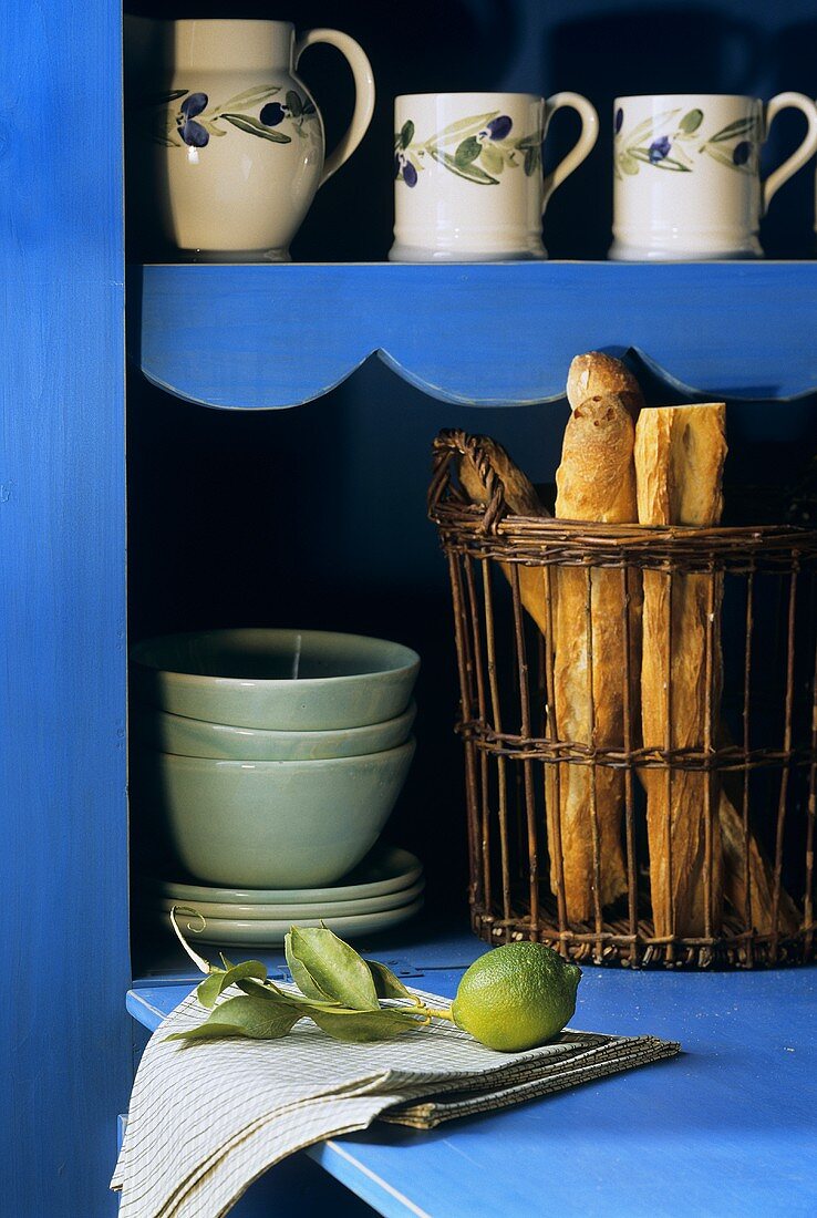 Mediterranes Geschirr und Brotkorb in blauem Schrank