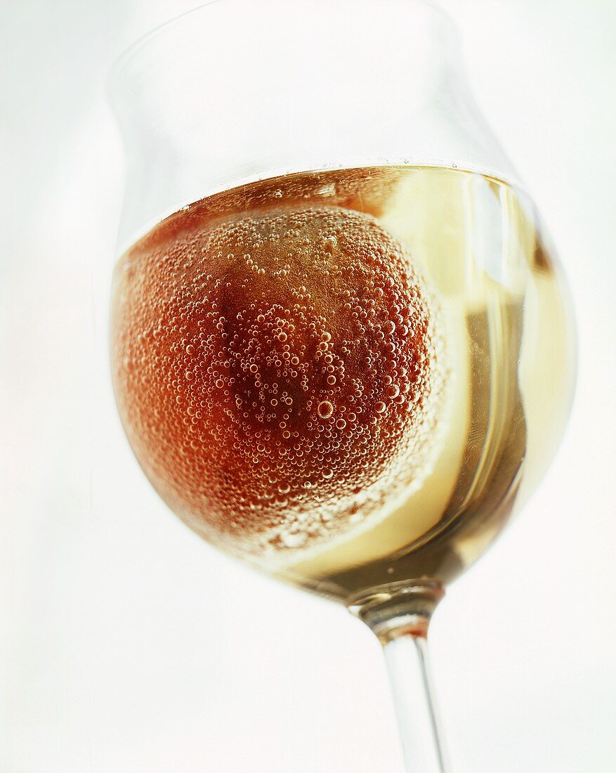 Kullerpfirsich ('rolling' peach in champagne) in glass