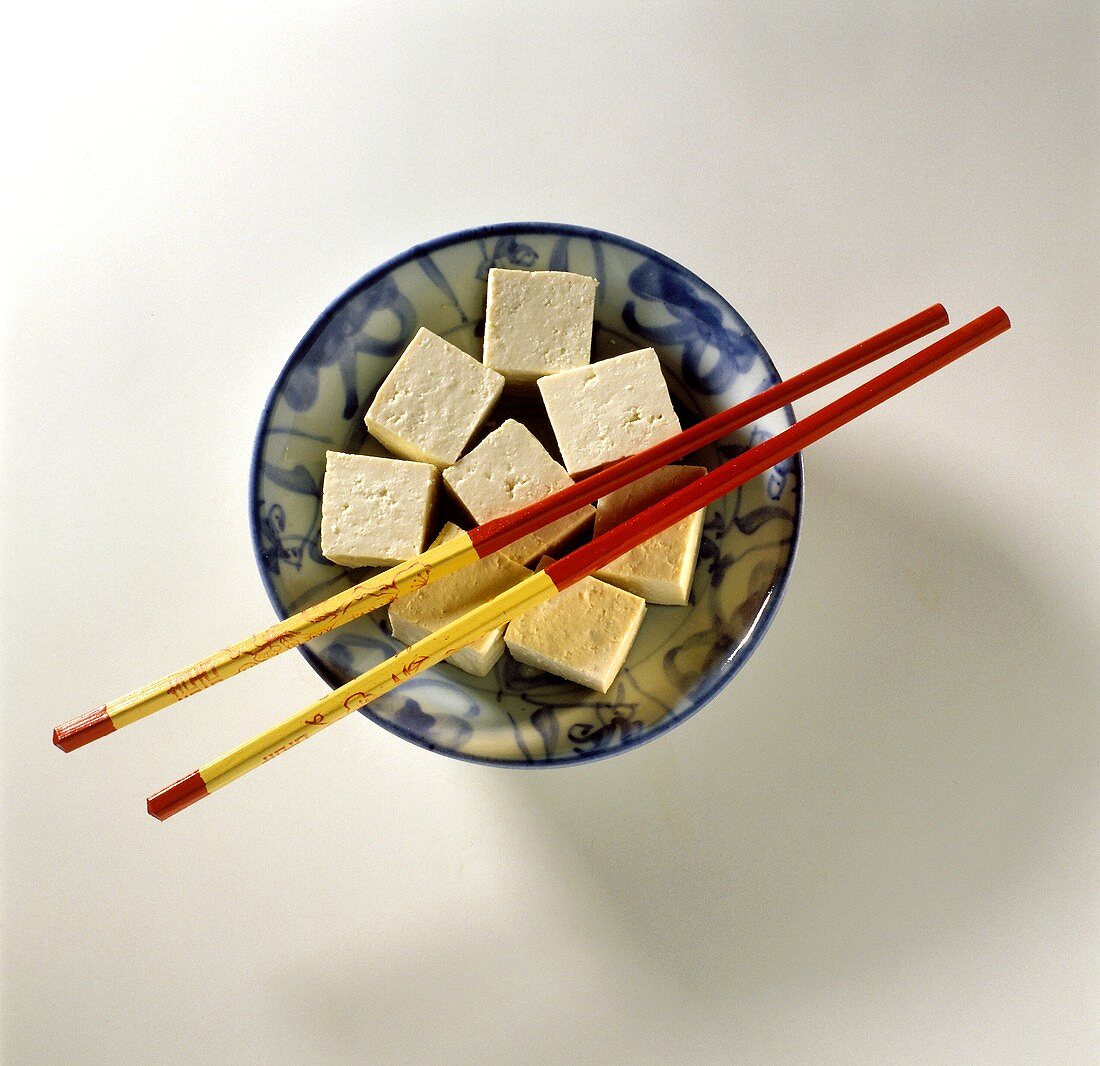 Tofuwürfel auf einem Teller mit Stäbchen