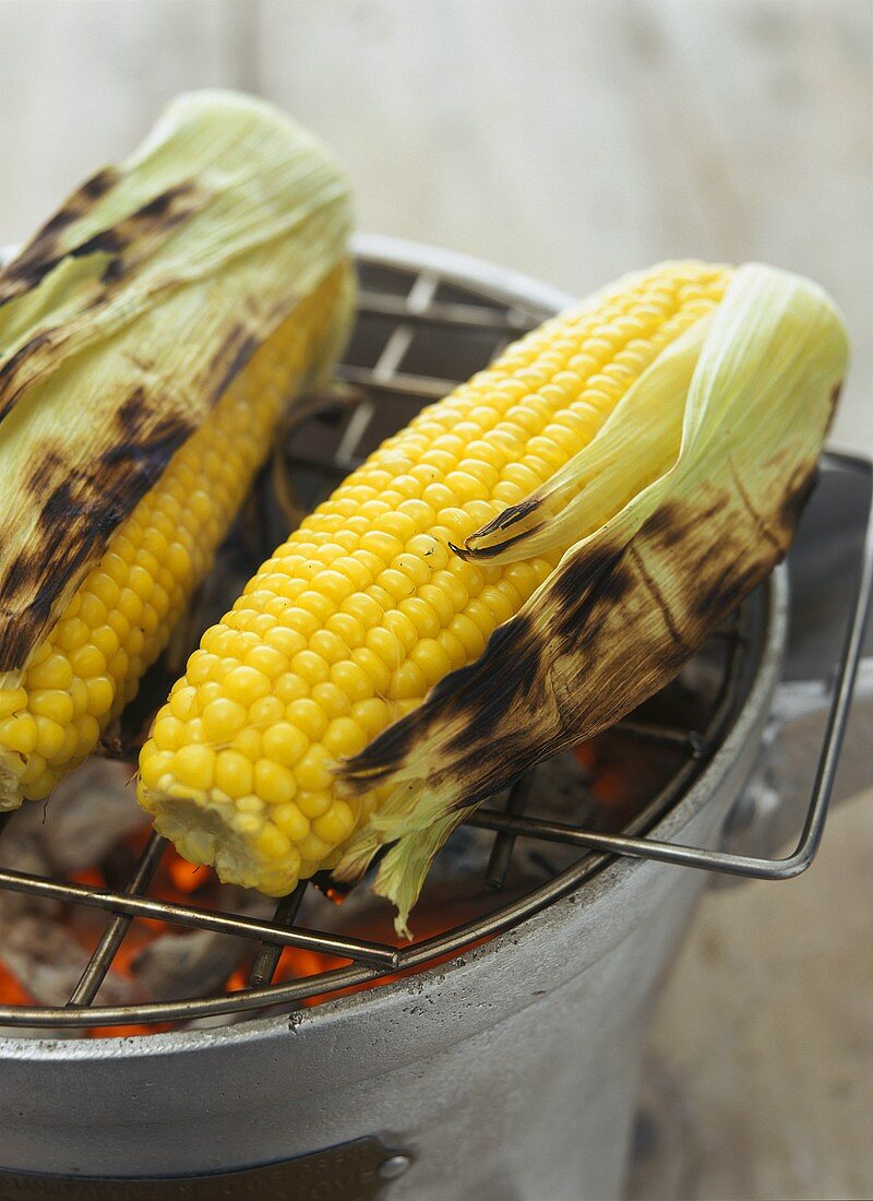 Gegrillte Maiskolben auf glühendem Grill