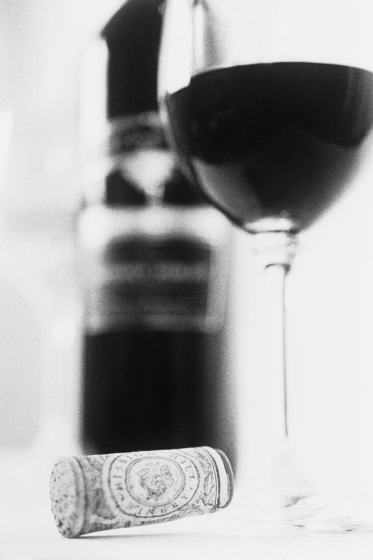 Eine Flasche und ein Glas Rotwein und ein Weinkorken
