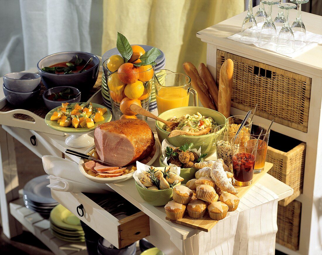 Brunch buffet with roast ham, muffins, salad and fruit