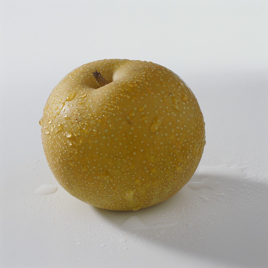 A nashi fruit with drops of water