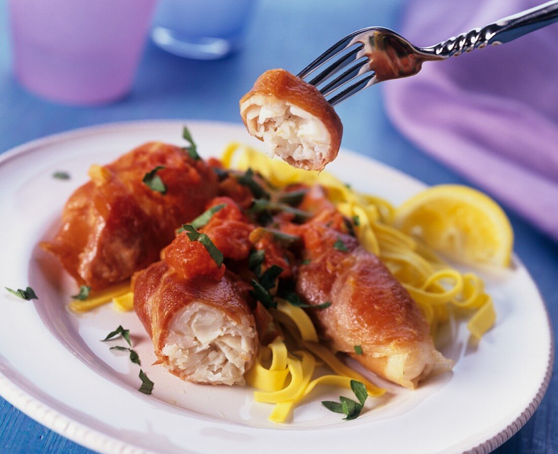 Fish fillet wrapped in bacon, with peeled tomato & pasta