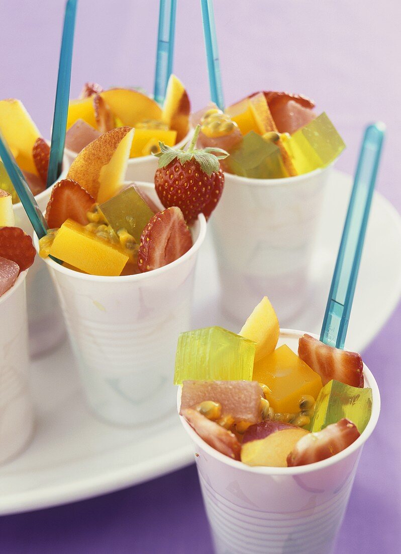 Fruit salad with jelly cubes in plastic pots