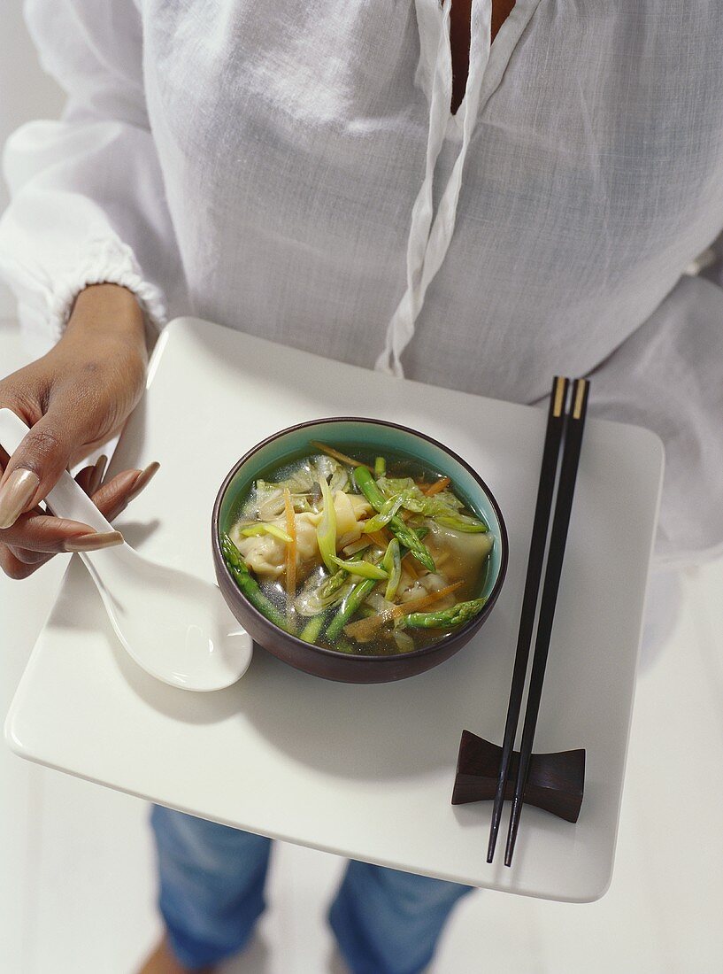 Model holding tray with Asian vegetable soup