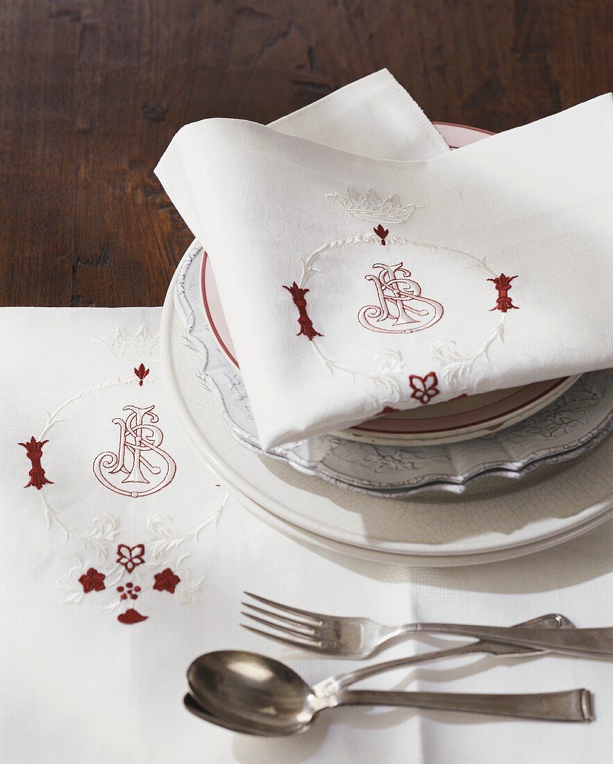 Place setting with embroidered fabric napkin