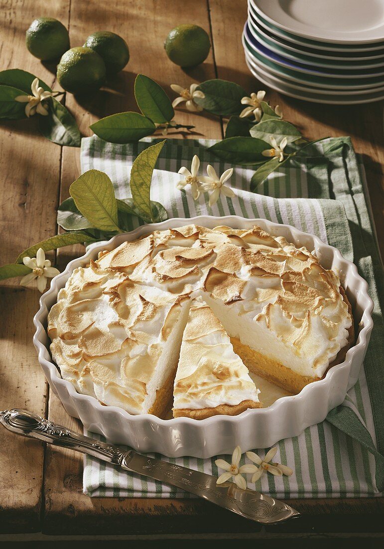 Key lime pie in baking dish, partly sliced