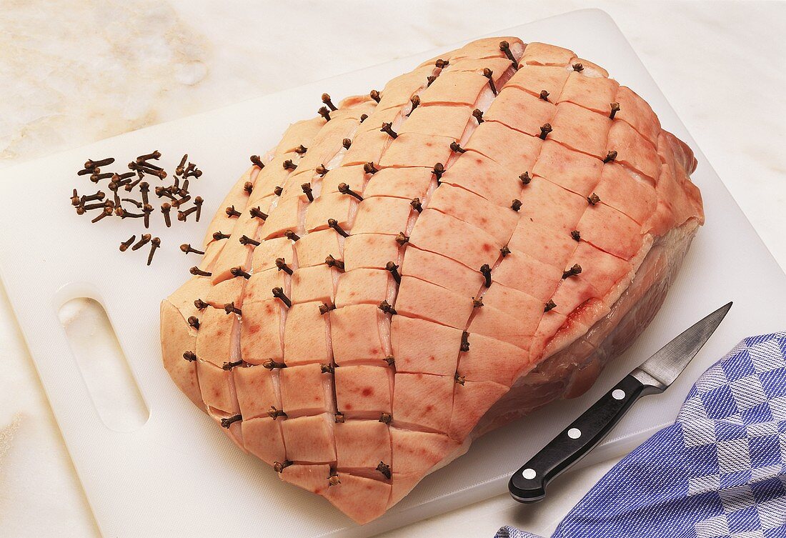 Raw joint of pork studded with cloves
