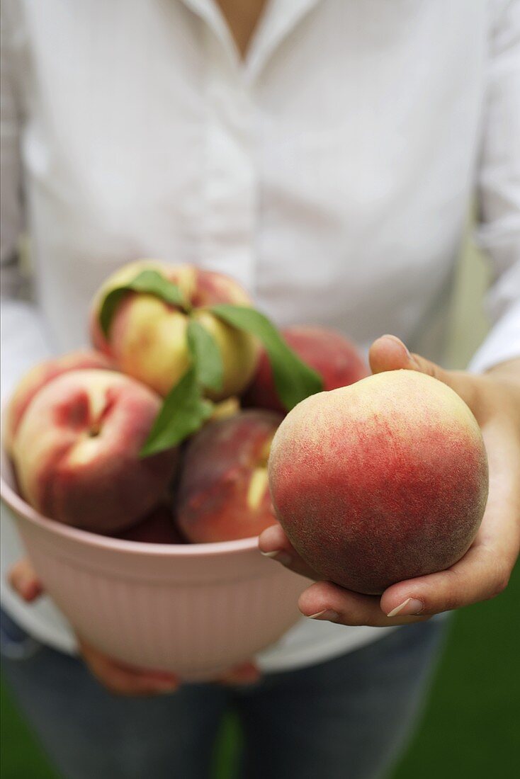 Woman holding fresh peaches