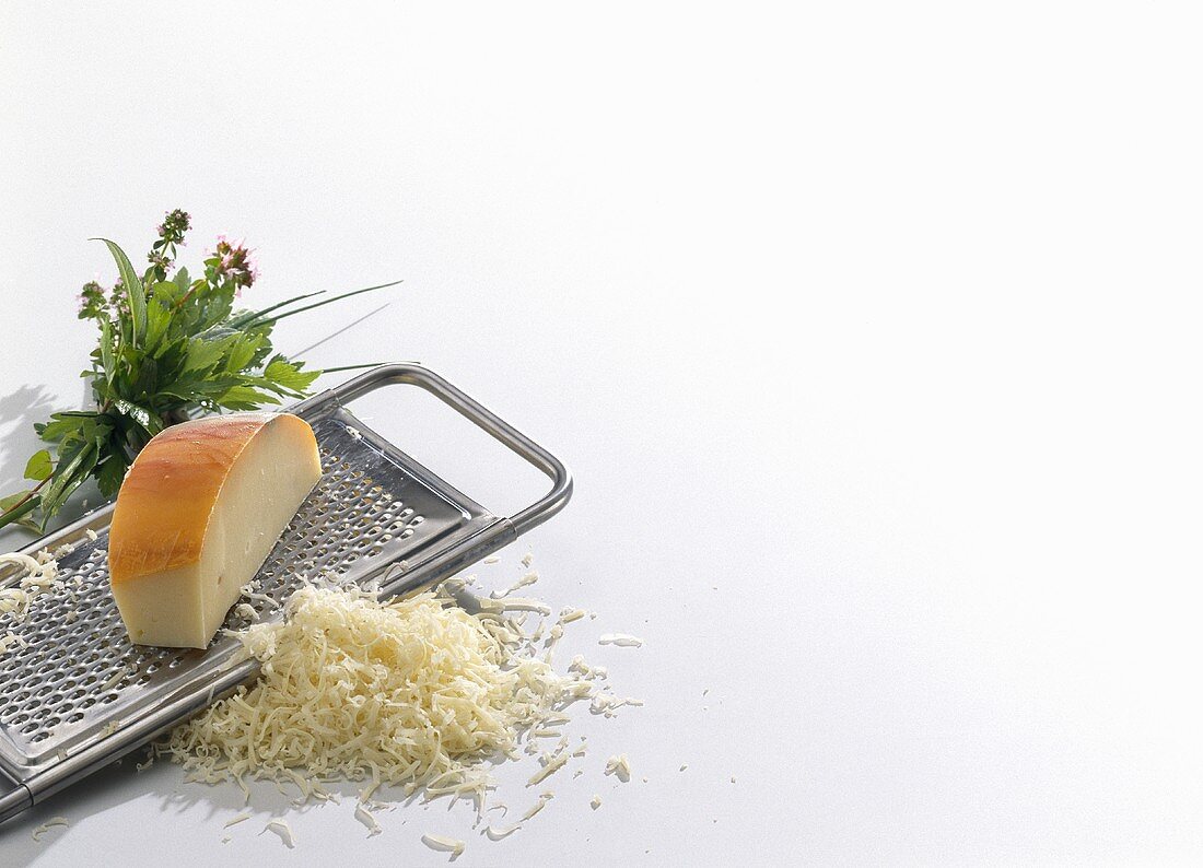 Grated cheese with grater and herbs