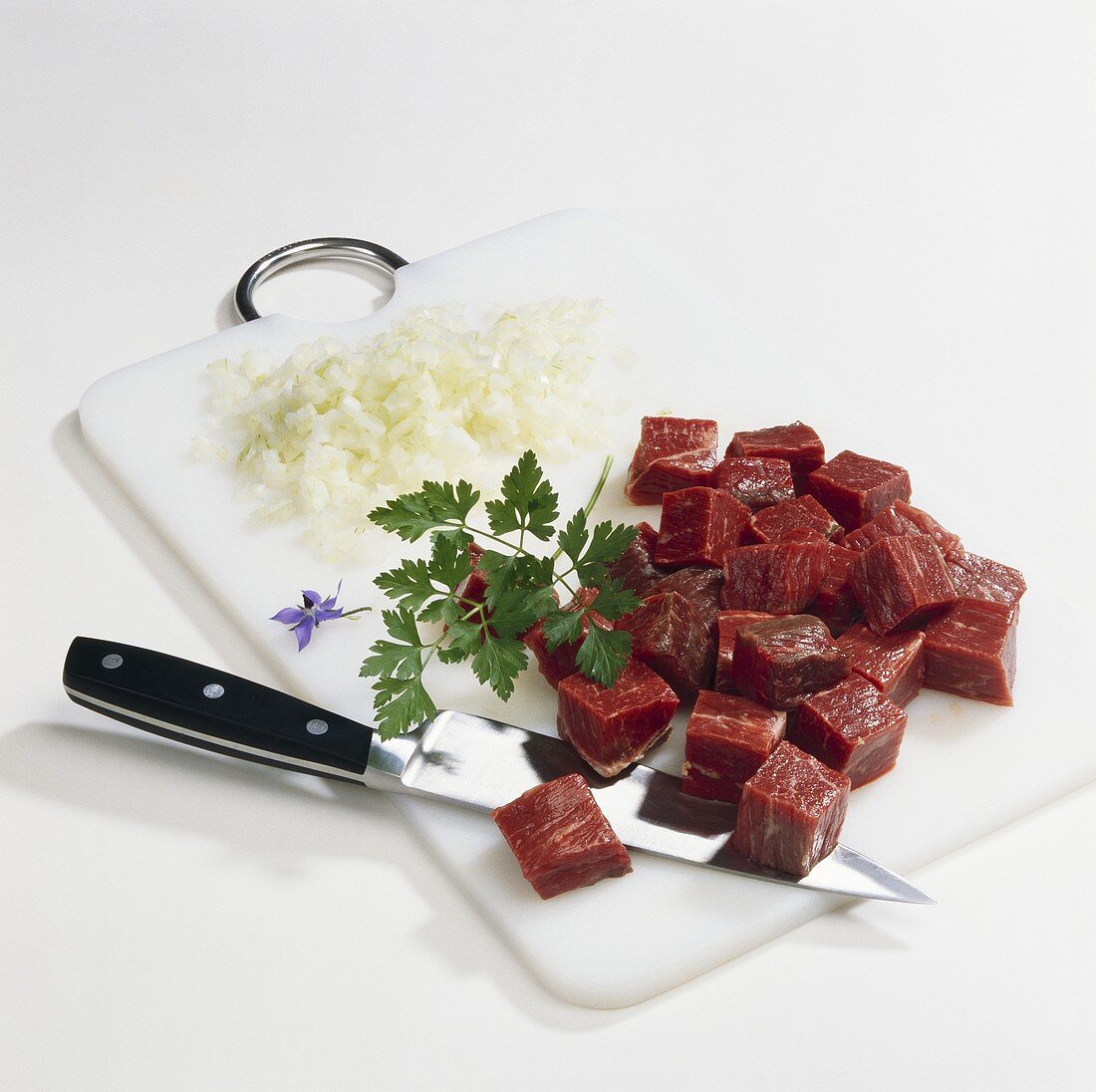 Beef and onions, diced, parsley and knife