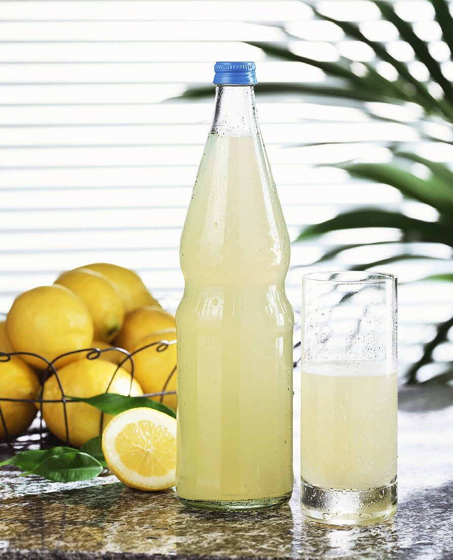 Zitronenlimonade in Glas und Flasche
