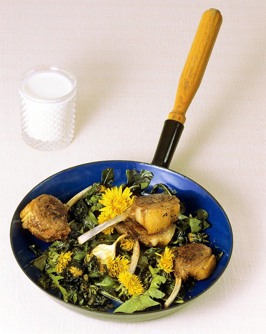Lamb cutlets with fried dandelion leaves & flowers in frying pan