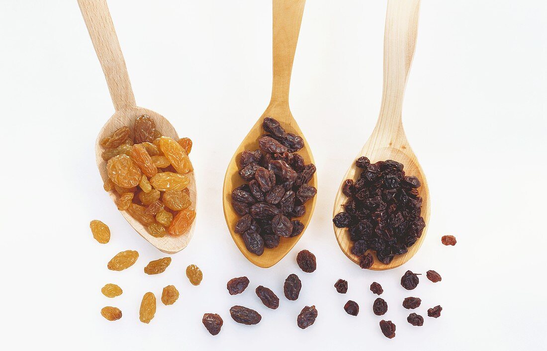 Sultanas, raisins, currants on wooden spoons