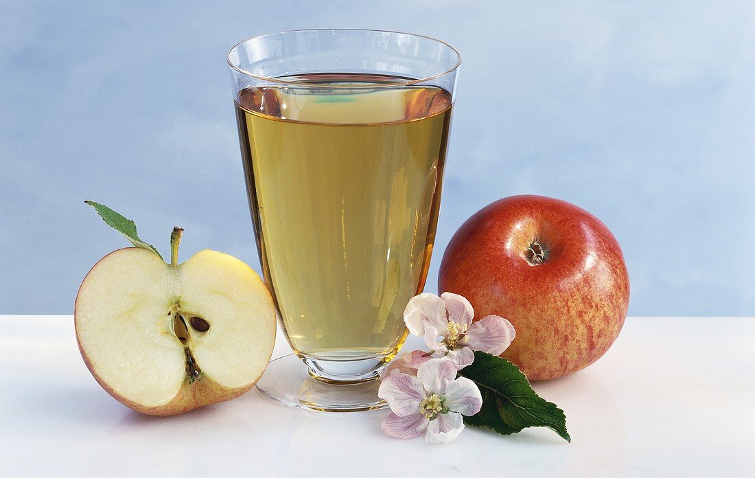 Glass of apple juice, fresh apples and apple blossom