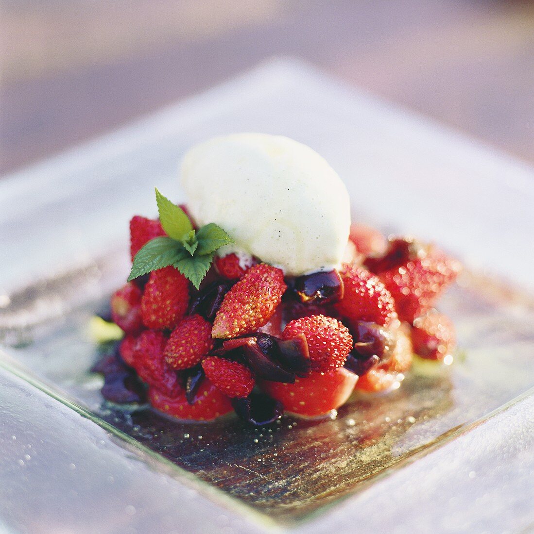 Vanilla ice cream on wild strawberries with olives