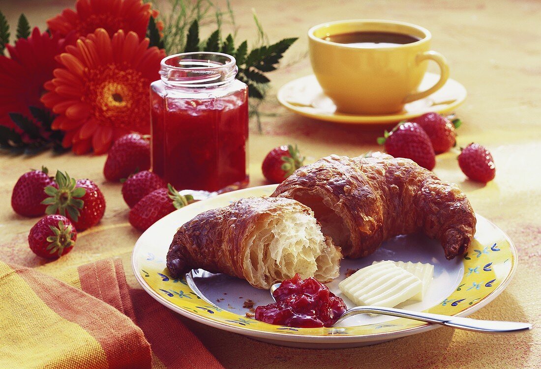 Frühstück mit Croissant und Erdbeermarmelade